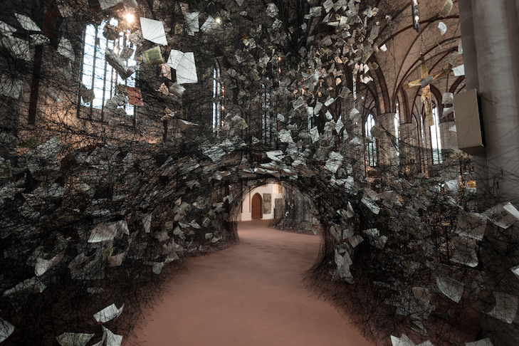 Chiharu Shiota 6 Lost Words, 2017, | Installation: black wool, bible pages | Museum Nikolaikirche, Berlin, Germany | Photo by Leo Seidel, Copyright VG Bild-Kunst, Bonn, 2019 and the artist