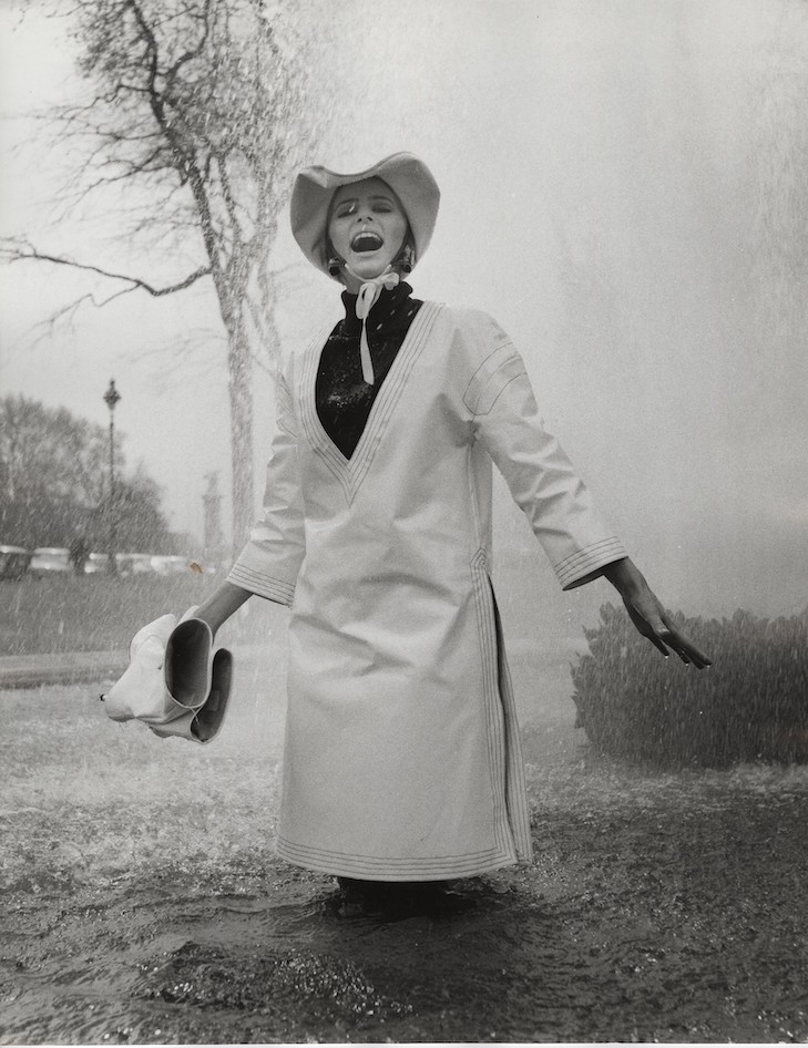 Jill Kennington wearing white PVC rain tunic and hat. Photograph by  John Cowan, 1963 Courtesy of Fashion Museum Bath/Image © John Cowan Archive